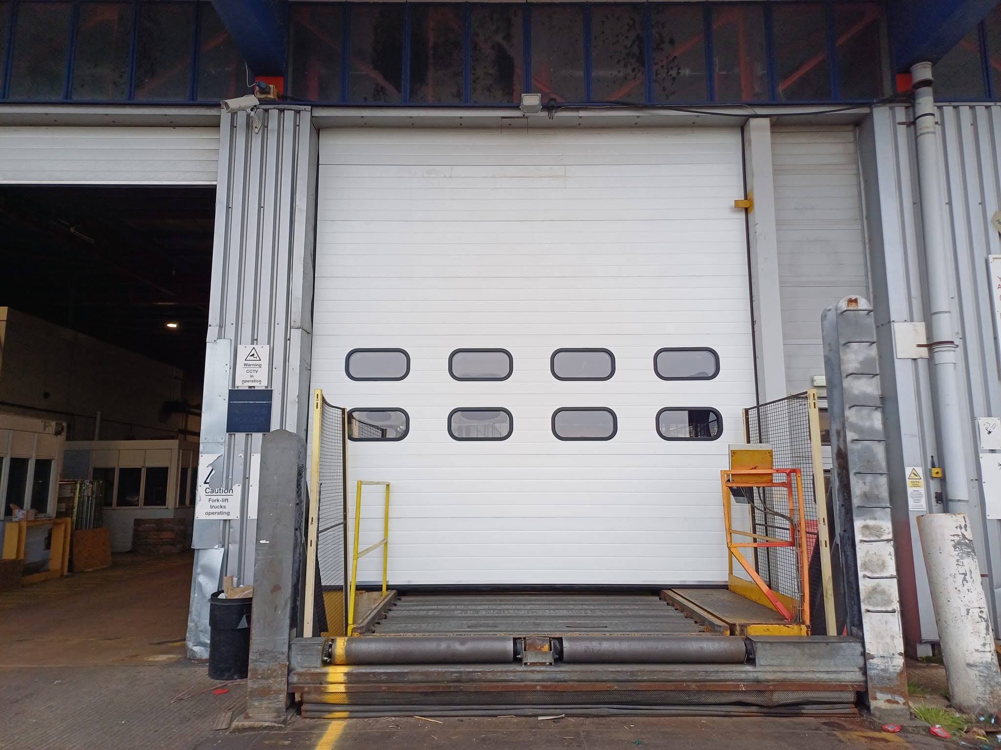 Large white sectional door with rows of vision panels