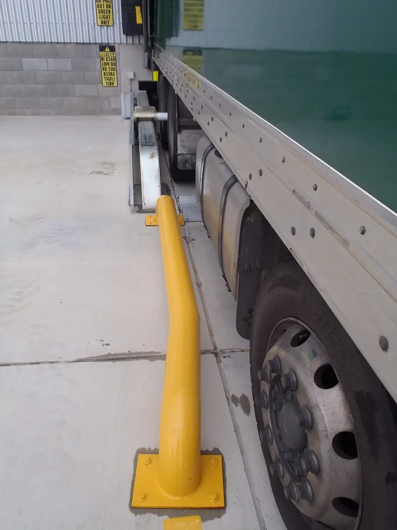 Wheel restraint installed alongside a loading-bay wheel guide